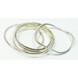 A silver interlocking bangle, London 1991, 7cm diameter, and two other silver slave bangles, 85gm