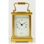 A miniature brass carriage clock, 8 day movement stamped 'Made In England' 8cm tall.