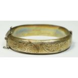 A silver hinged bangle, Birmingham 1962, engraved scroll decoration, presentation inscription, 21gm