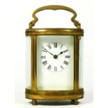 A French brass carriage clock, in oval form with enamelled dial and roman numerals, 8 day cylinder