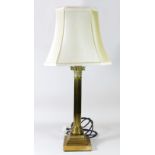 A solid brass table lamp, reeded column on a stepped base with a cream fabric shade. Overall