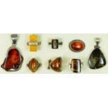 Eight silver mounted amber rings and pendants, 60gm.