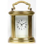 A French miniature carriage clock, brass case of oval form with enamelled dial and Roman numerals,