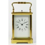 A brass repeating, hour and half hour striking carriage clock, white enamel dial with Roman numerals