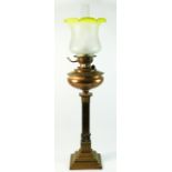 An early 20th century brass and copper oil lamp, having frosted glass tulip shade with copper