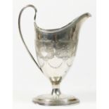 A George III silver bright cut cream jug, by Charles Hougham, London 1792, of helmet form, raised on