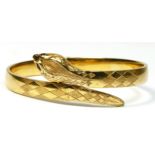 A vintage 9ct gold hinged snake bracelet, London 1963, with engraved decoration and garnet set eyes,