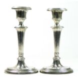 An Edwardian silver pair of candlesticks, Birmingham 1903, of fluted tapering form, raised on oval