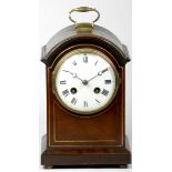 An Edwardian mahogany mantel clock, the white enamelled dial with Roman numerals and brass bezel,