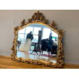 A substantial modern giltwood overmantle mirror in the Rococo style with floral scroll work.