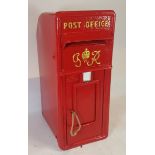 A Royal Mail mounted iron fronted letter box, of typical arched form, painted in red with relief