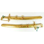 A pair of souvenir short sword/daggers from Saudi Arabia, gilt metal and niello decorated with sing