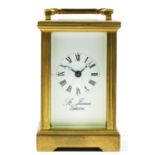 A miniature brass carriage clock with 8 day movement, retailed by James Of London. 9cm tall.