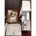 A ceramic toilet bowl, toilet seat, sink base with attached taps, a sink basin, sets of taps and