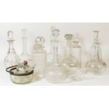 A collection of cut glass drink decanters together with a quantity of glass stoppers.