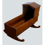 A 19th century oak childs cradle, having arched hood and rockers. W86, D34, H66cm.