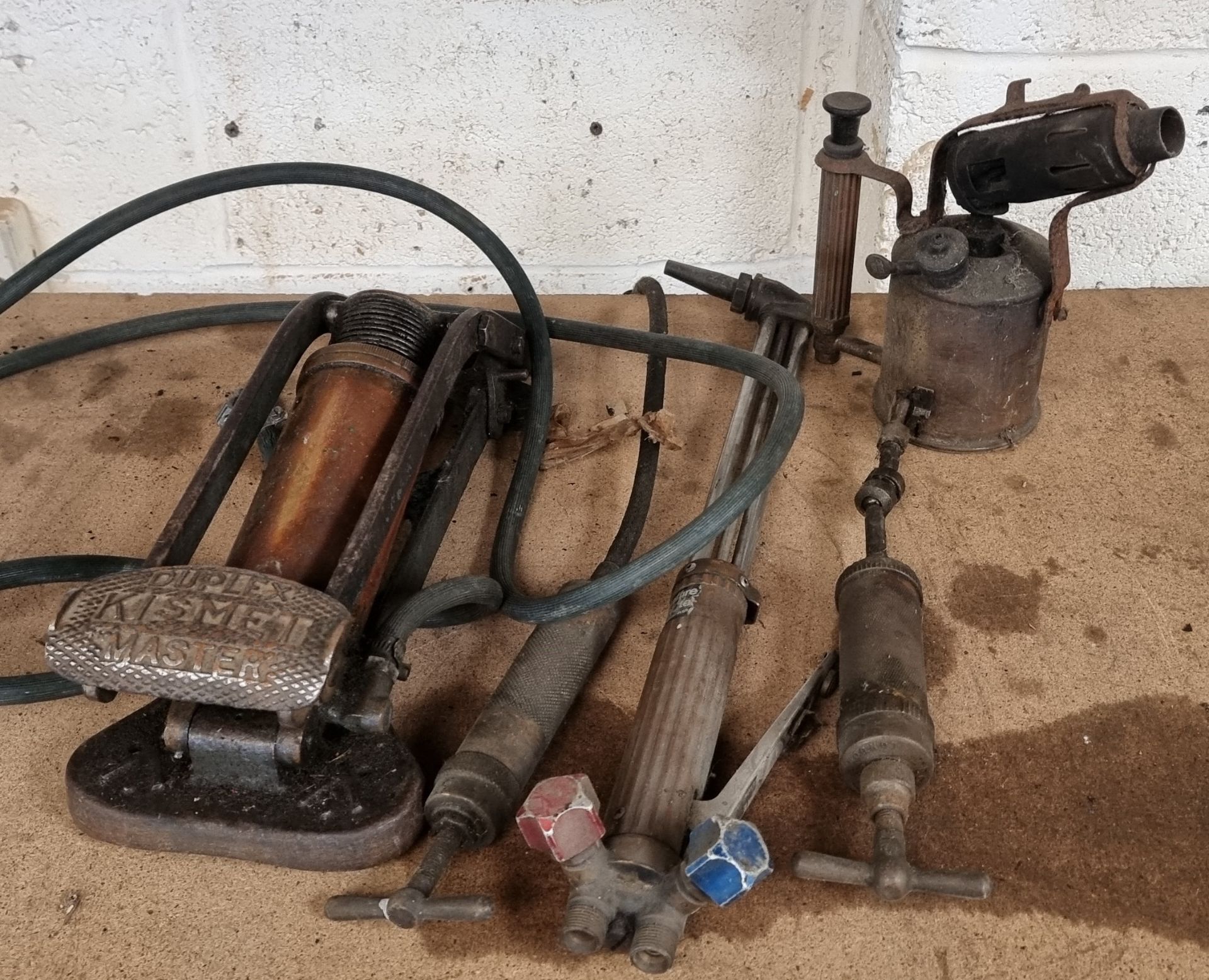 A Duplex Kismet Master foot pump, a Tecalemit brass grease gun, another pump, a blow lamp and a