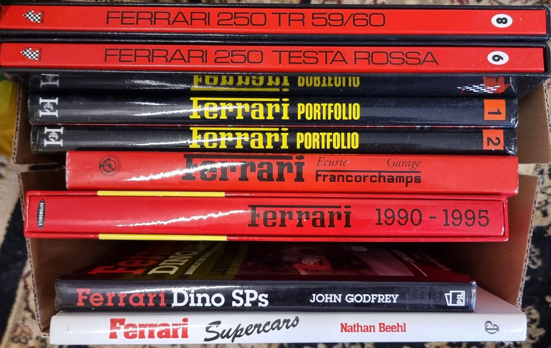 A collection of 22 books related to Ferraris, including Ferrari Ecurie Garage by Nada and Ferrari