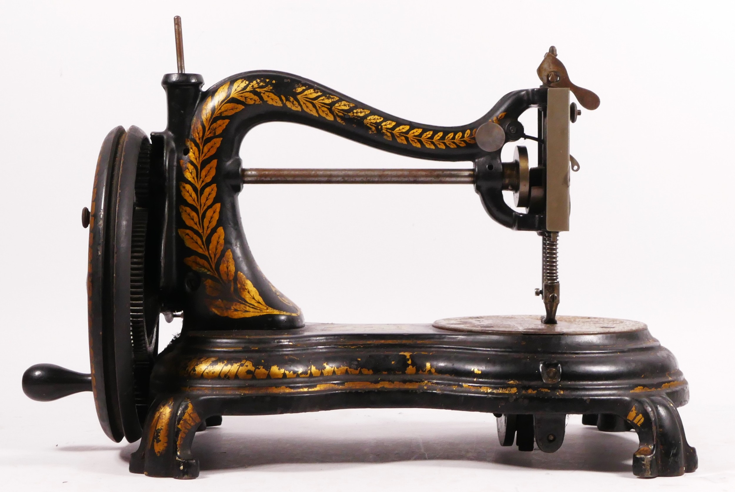 A Jones hand sewing machine, serpentine/cat back, with gilt floral decoration, 38cm long