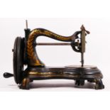 A Jones hand sewing machine, serpentine/cat back, with gilt floral decoration, 38cm long