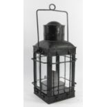A hand lantern in protective metal cage with burner