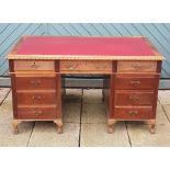 An early 20th century mahogany twin pedestal desk, having scalloped edge top with inset leather