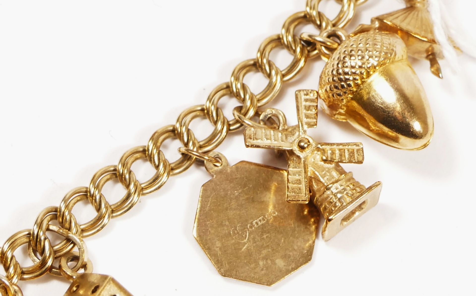 A 9ct gold curb link bracelet, with multiple charms, including a church and a traffic light, 32.4gm - Image 6 of 6