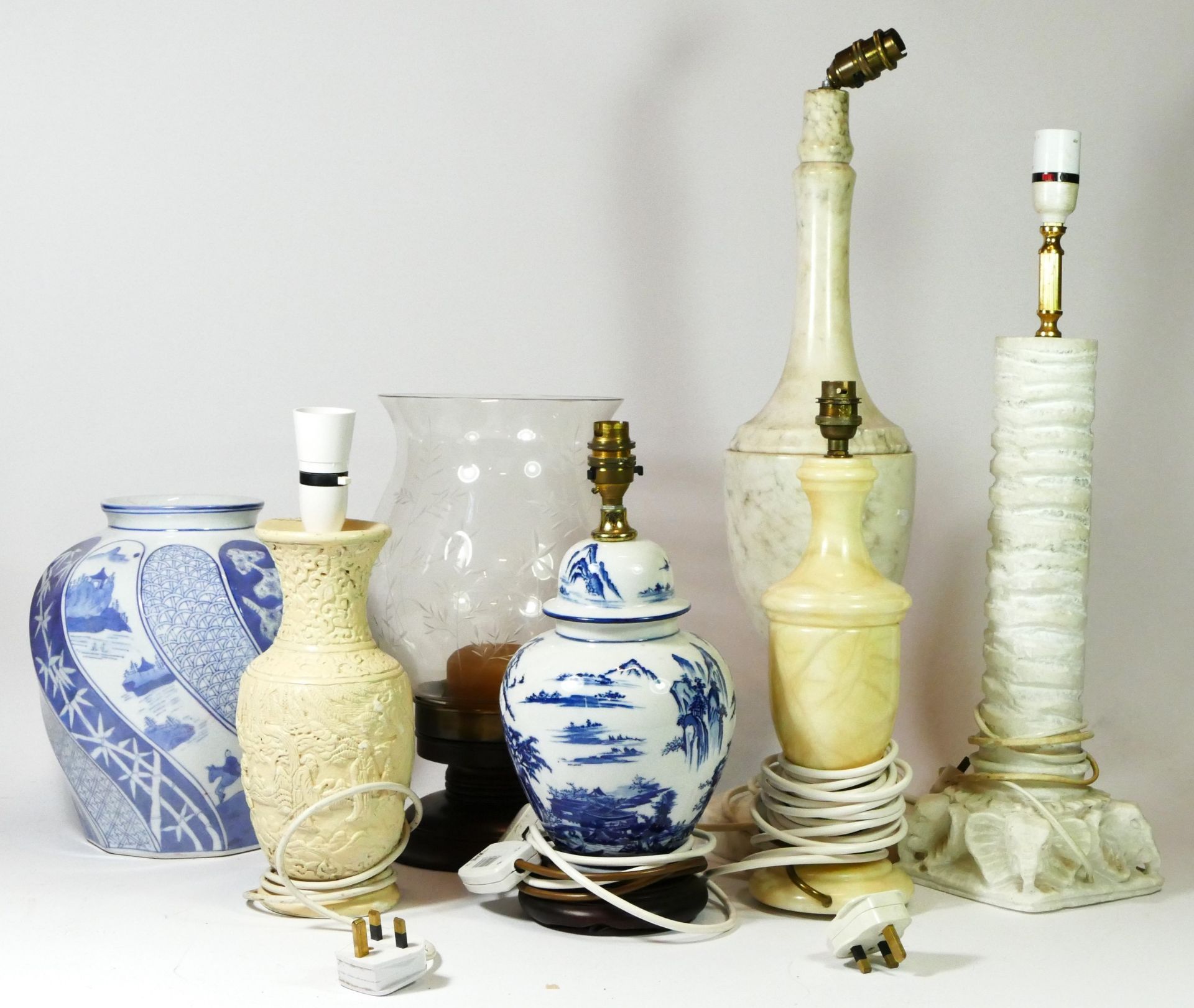 A collection of table lamps, to include marble and stone examples, together with a blue & white