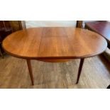 A mid 20th century Mcintosh teak dining table, extendable with integral leaf, together with a