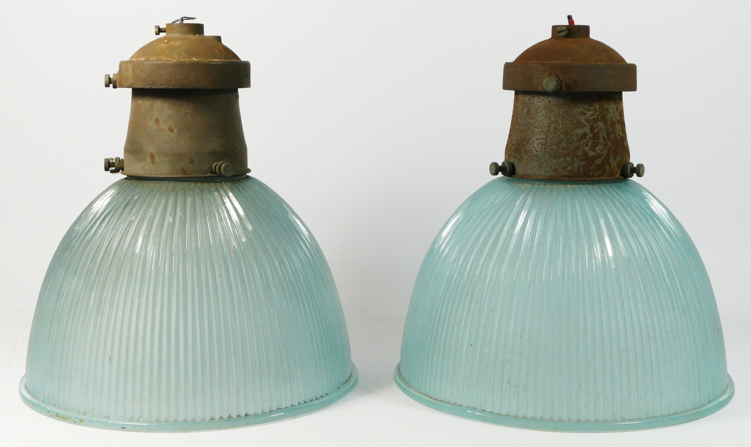 A pair of mid 20th century holophane prismatic glass pendant ceiling lights, with metal