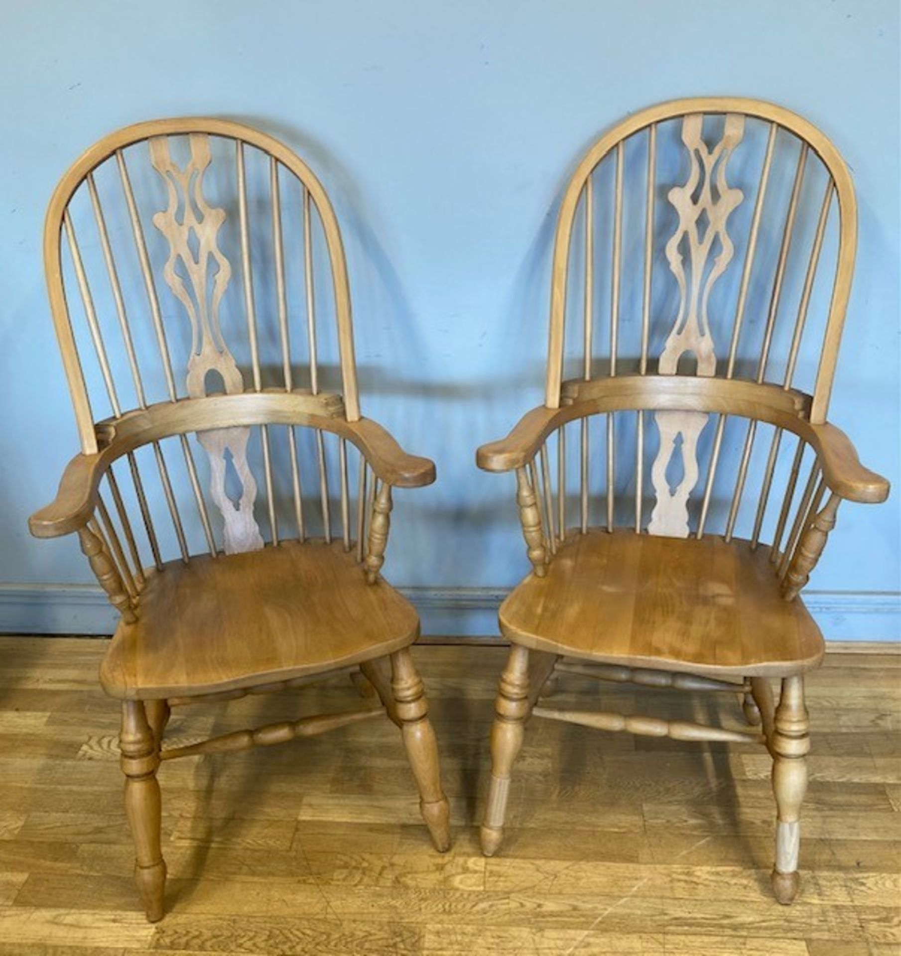 A pair of Windsor armchairs, the shaped comb backrests with back splates, turned rails and shaped
