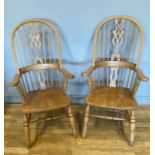 A pair of Windsor armchairs, the shaped comb backrests with back splates, turned rails and shaped