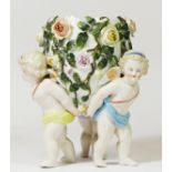 A Victorian German Sitzendorf porcelain vase, having three cherubs holding an egg shaped vase