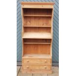 A stripped pine library bookcase/display cabinet, having shaped pelmet with three open shelves and a