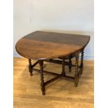 An early 20th century oak gateleg dining table, having moulded edge top, on barley twist supports
