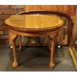 A light oak occasional table, having inlaid top under glass, raised on turned legs with claw and
