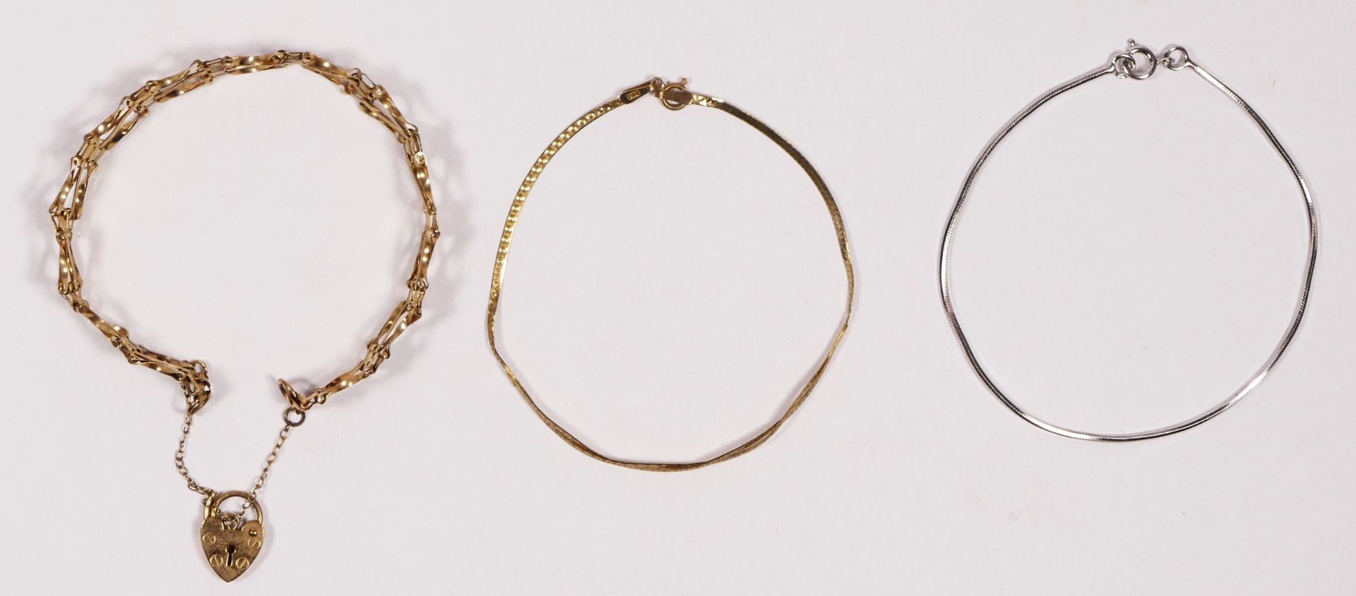 A 9ct gold gate link bracelet, a 9ct gold flat link bracelet and a 9ct white gold bracelet, 7gm.