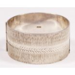 A vintage silver bangle, Birmingham 1974, with textured front panel, 32mm wide, 76gm