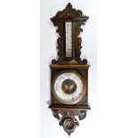 An Edwardian carved oak wall barometer