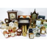 A collection of manual wind and quartz movement mantel clocks, traveling alarm clocks and