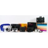 A collection of instant film cameras, to include a Fuji Instax 200, a Polaroid EE 100, a