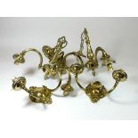A pair of cast brass chandeliers, each consists of three arched arms holding a shade,