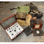 A collection of military items, to include gas masks, belts, an ammunition box, a flying hat, and