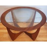 A 1960s G-Plan 'Astro' glass topped teak round shaped occasional table, having intersecting curved