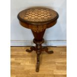 A Victorian walnut games and work table, the circular hinged top enclosing a fitted interior and