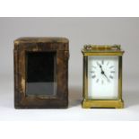 A brass cased carriage clock, four bevelled glazed sides with balance wheel window, white enamel