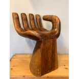 A carved hardwood seat in the form of a open hand. W32, D36, seat height 34cm.