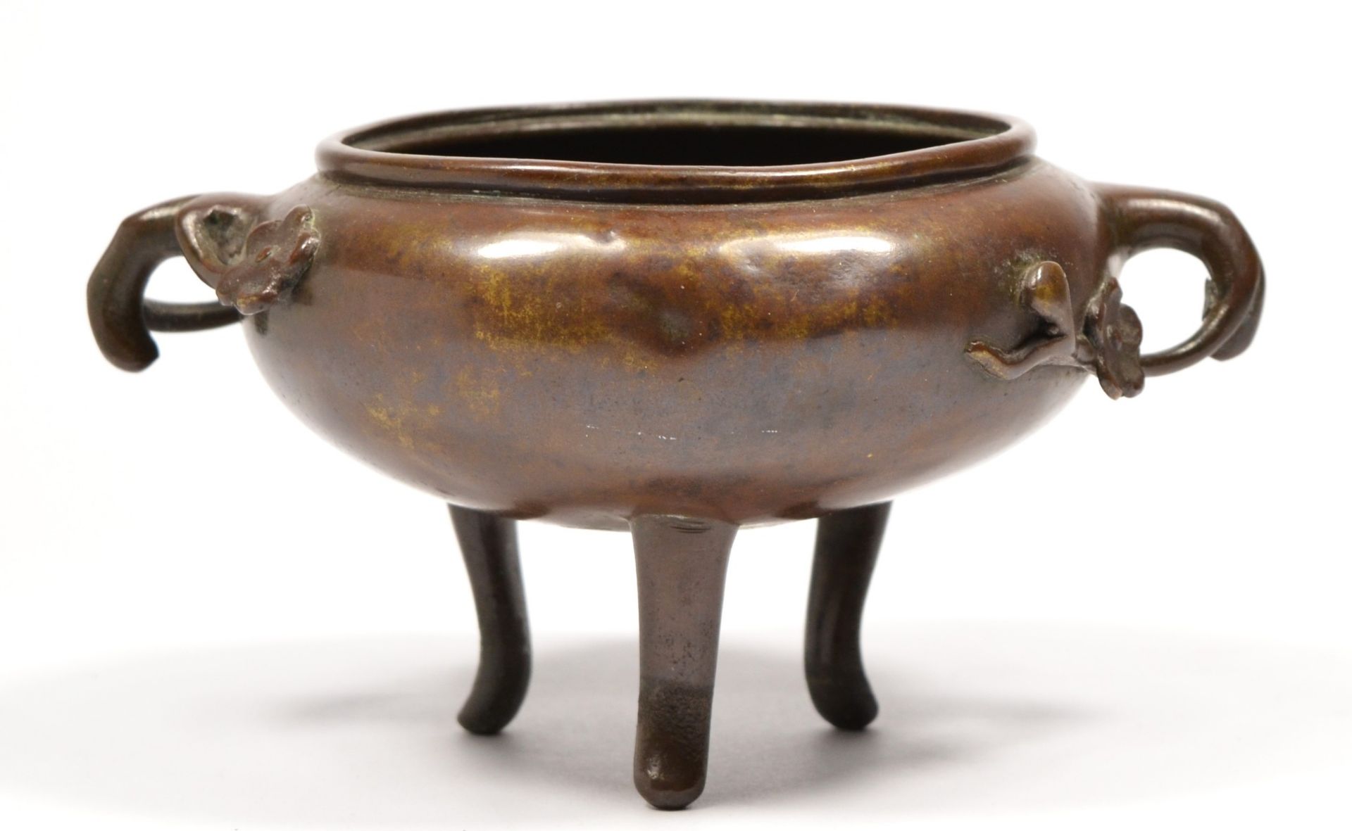 A Chinese bronze censor bowl, with peonie branch handles, raised on three legs, 15cm across handles.