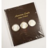 Three silver proof Liberty dollars, 2004, cased, together with a Eagle Dollar unused folder. To be