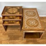 A 1970s teak tiled nest of three graduated tables, stamped Made In England, together with a